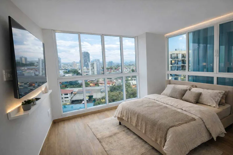 Recámara con ventanales de piso a techo y vista a San Francisco en PH Omar Park View